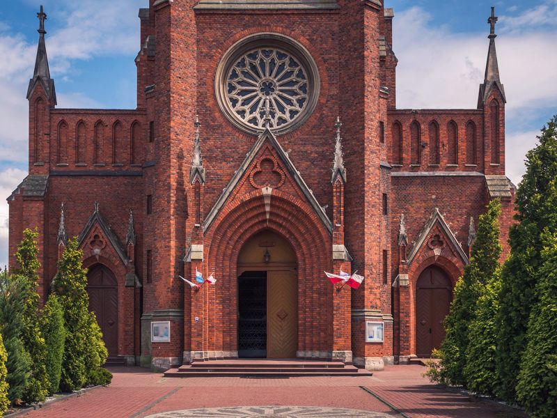 Archiwolta ostrołukowego portalu wejściowego w ceglanej fasadzie kościoła w Sulejowie